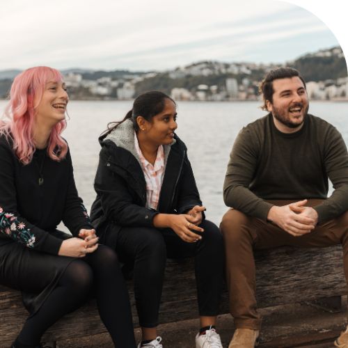 Flexible working at Tourwriter Three happy professionals sitting at the waterfront